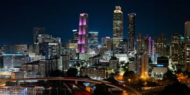 Night view of Atlanta city skyline with illuminated buildings and highways.