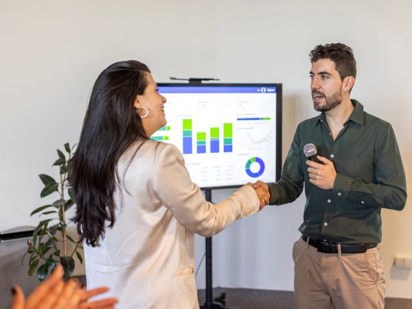 Man and woman shaking hands during presentation.