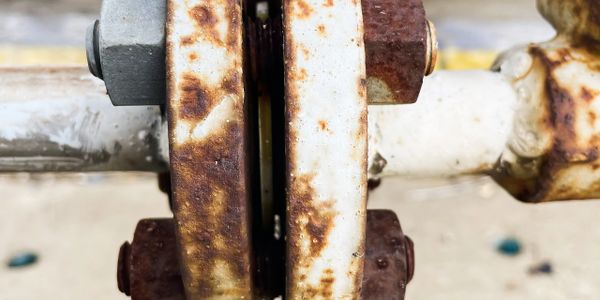 Close-up of a rusty metal flange connection with bolts.