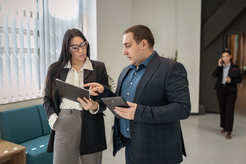 Business partners reviewing documents and discussing important information in a corporate setting