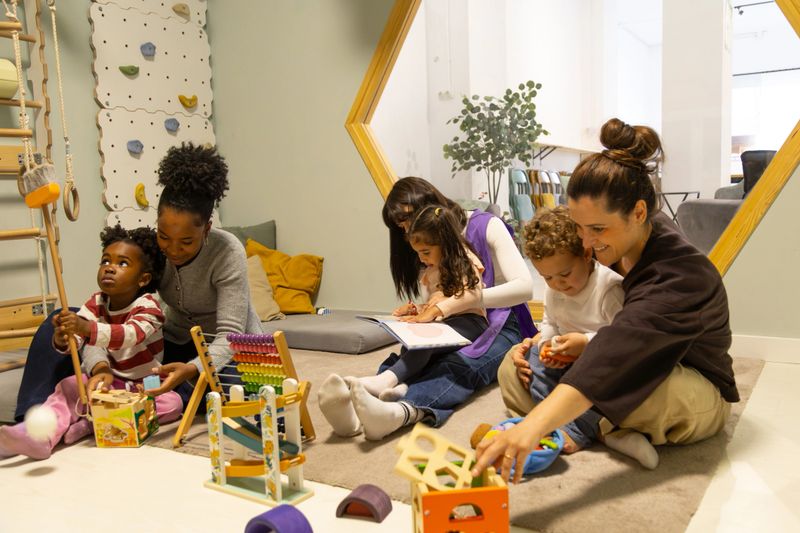 Young multi ethnic children interacting with teachers, engaging in educational play and reading activities in a modern daycare setting