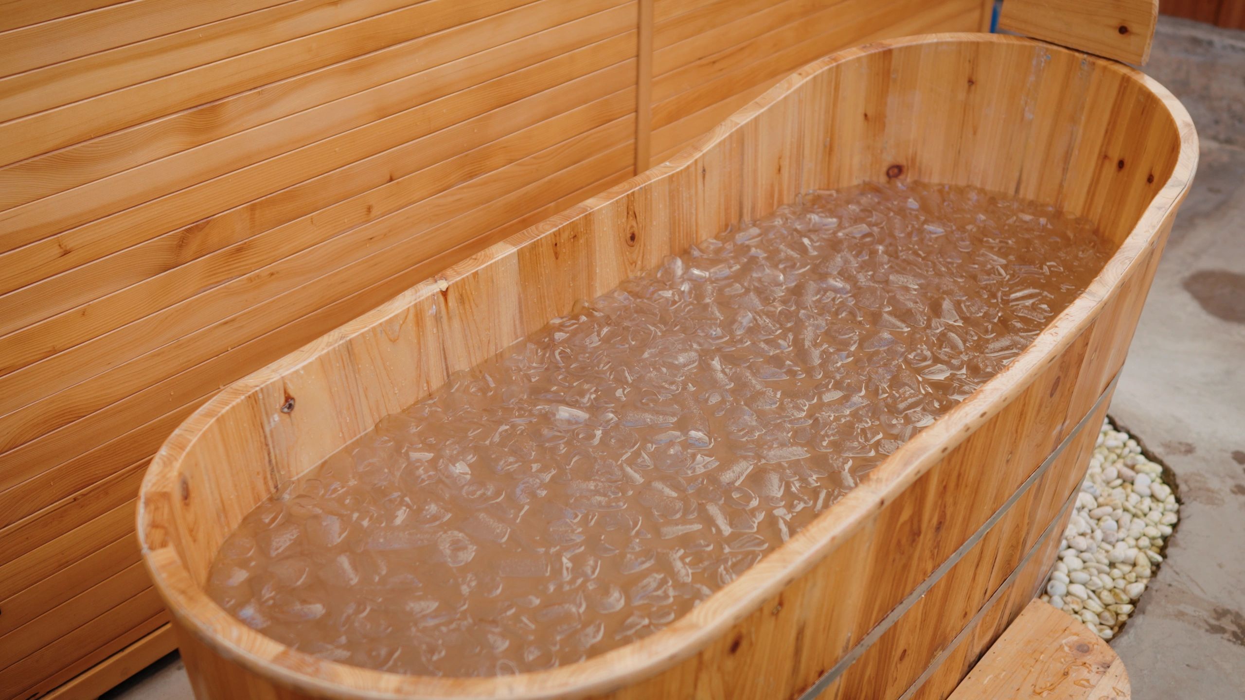Wooden cold plunge tub filled with ice water