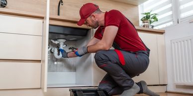 Plumber fixing a kitchen sink pipe.