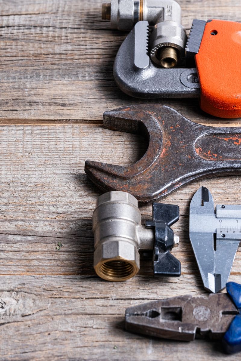 Variety of plumbing tools on wooden background. Top view with copy space