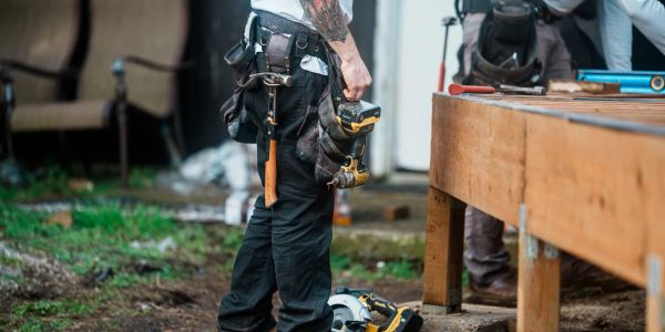Construction worker holding a power drill on a job site.