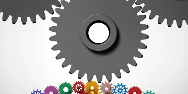 Large black gears turning above smaller colorful gears.
