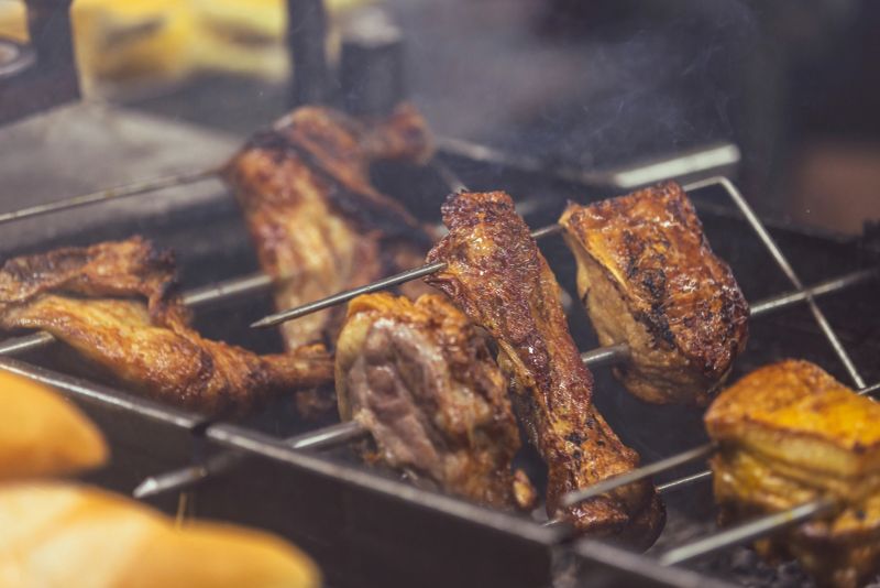 Asian street food market view, grilled meats are cooking on barbecue on the street.