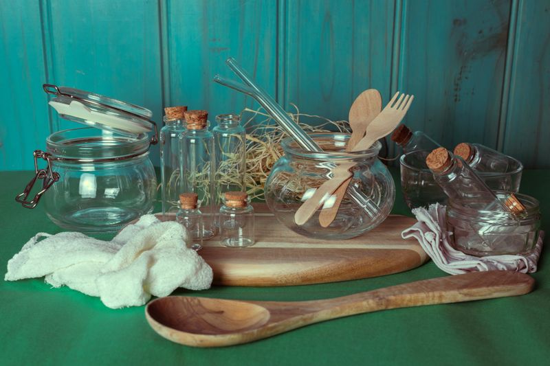 Wooden utensils and reusable glass containers arranged in natural light. Zero waste, green living, minimal design, and eco-conscious household.