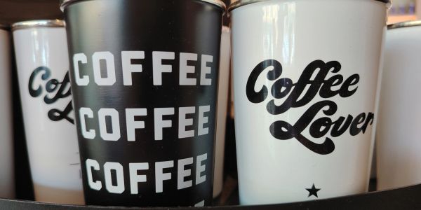 Two coffee cups with bold text designs.