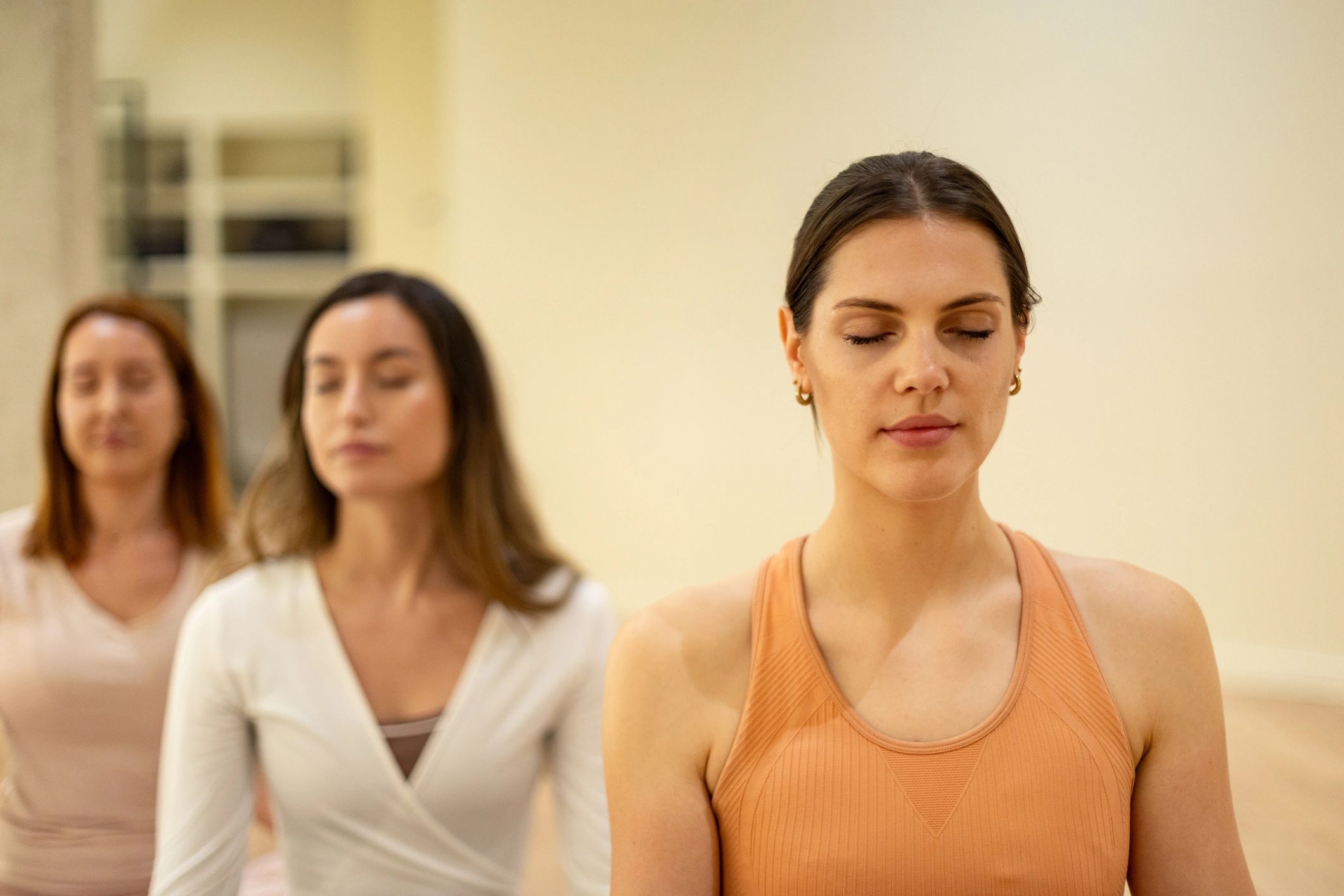 People breathing calmly with eyes closed in a group class