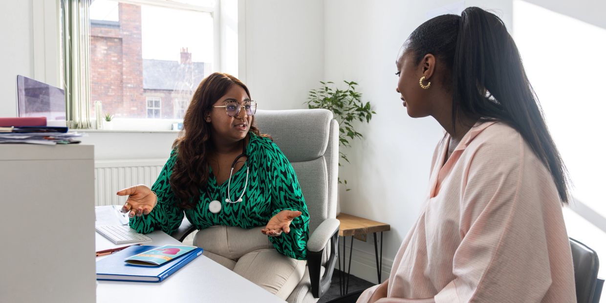 Doctor consulting a patient in a bright office.