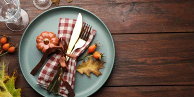 Autumn-themed place setting with pumpkin and fall leaf.