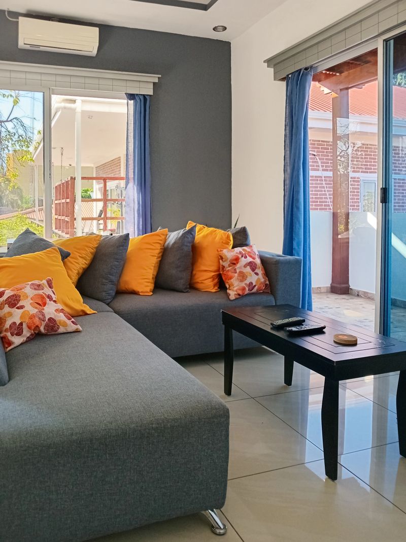 Comforting living room with grey sectional sofa and bright orange cushions