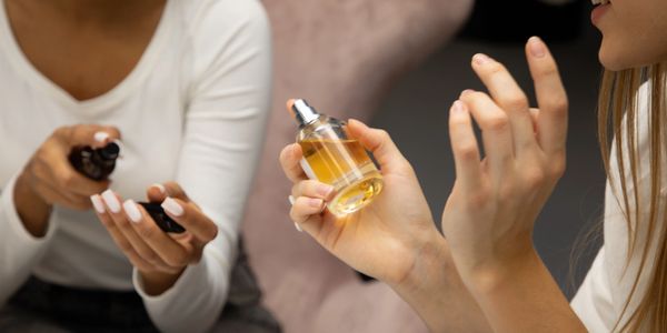 Two women sharing and testing perfumes.