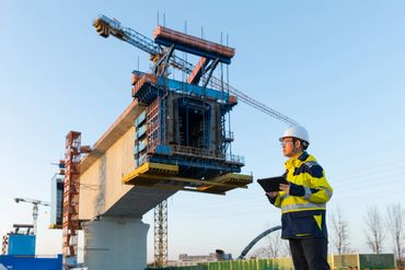 Construction worker inspecting a bridge under construction.