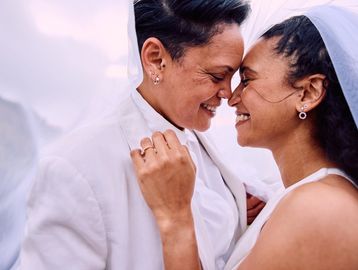 Two brides share a joyful, intimate moment.