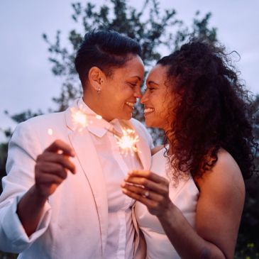 Two brides, newly wedded embrace during their wedding ceremony