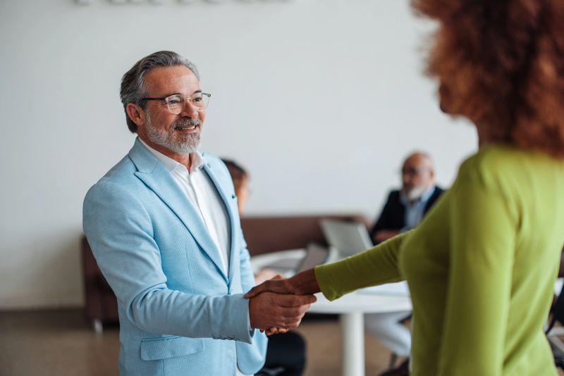 A professional handshake conveying trust and partnership, set in a bright office environment that fosters collaboration and positive relationships between individuals.