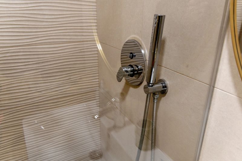 Contemporary wash area shows sleek metal fixture faucet tap hose steel silver