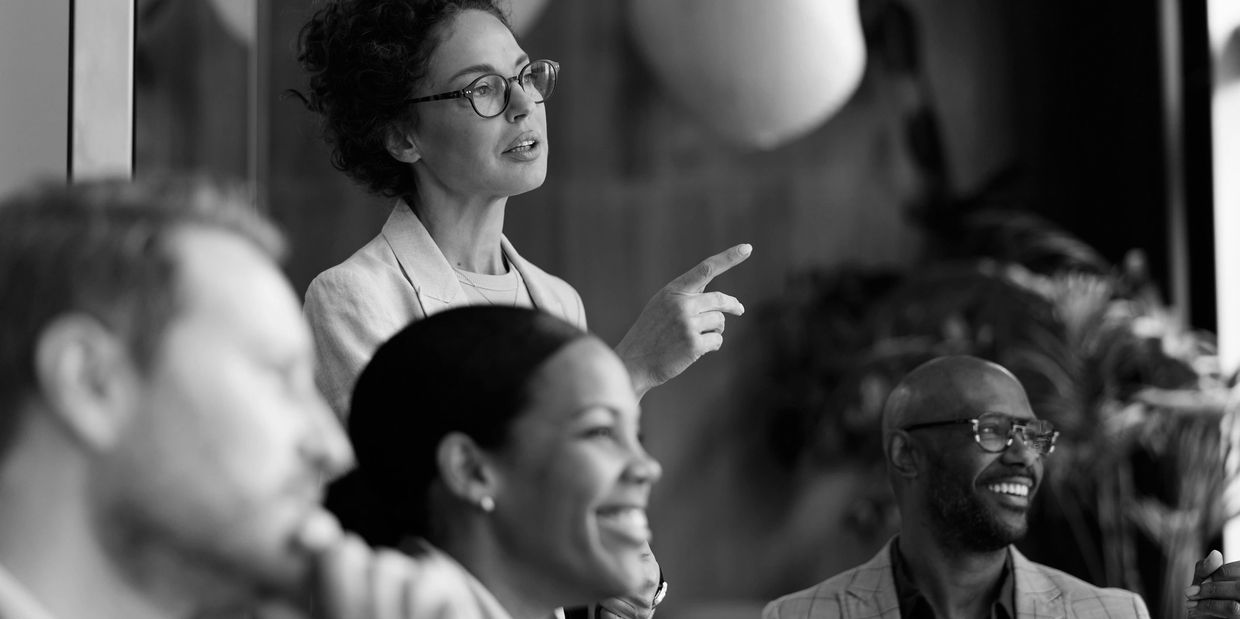 Woman presenting ideas to a group in a meeting.