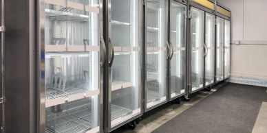Empty glass door refrigerators in a store or storage.