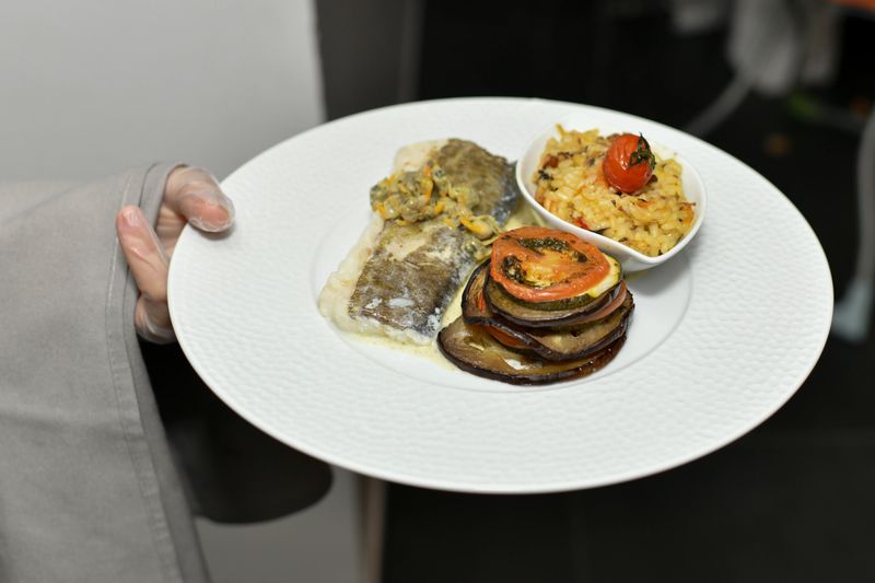 Chef serving gourmet plated dish with artistic presentation. Fine dining restaurant cuisine with premium ingredients. Ideal for gastronomy, culinary art, and luxury food concepts.