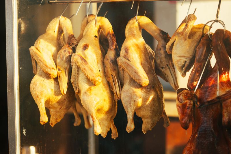 Asian street food market view, grilled meats are cooking on barbecue on the street.