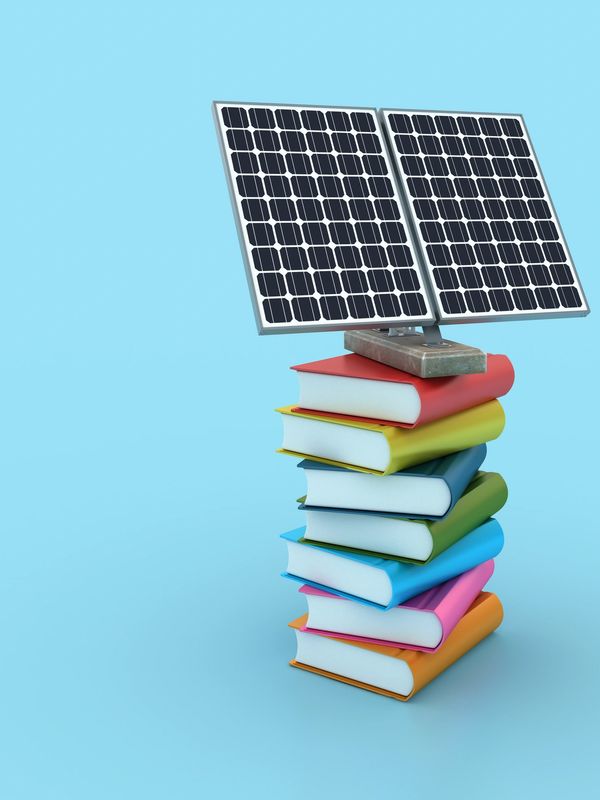 Solar panel mounted on a stack of colorful books against a blue background.