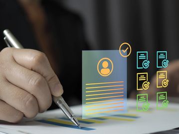 Hand holding pen over document with digital approval icons.