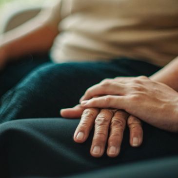 Two hands gently holding each other.