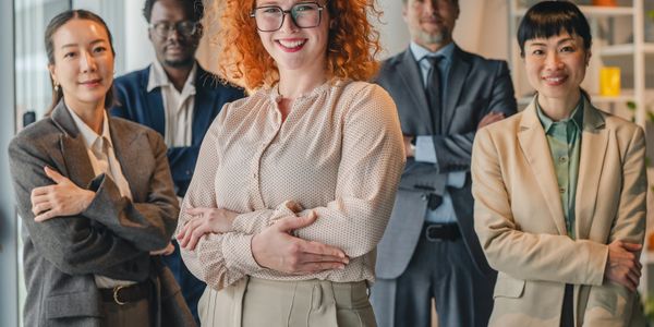 Confident diverse business team posing together with arms crossed in office.
