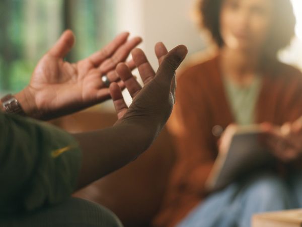 Person discussing with expressive hand gestures to a listener.