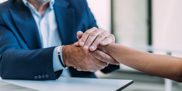 Handshake between two individuals in a business setting.
