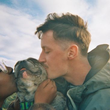 Man kissing a dog affectionately.