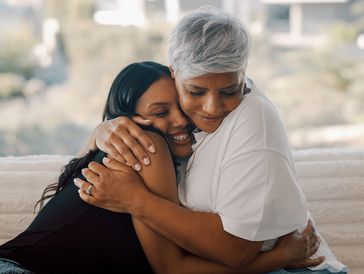 Two women sharing a warm, affectionate hug.