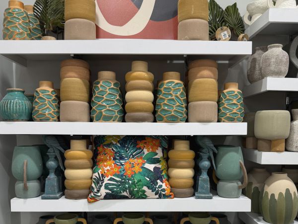 Shelves filled with decorative vases and a colorful floral cushion.