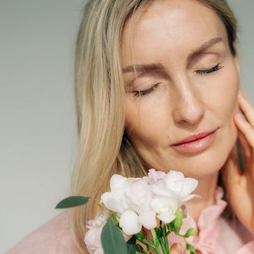 Woman with closed eyes holding white flowers.