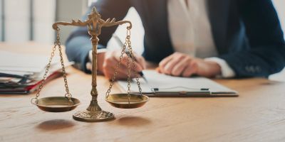 Legal scales and person writing on paper.