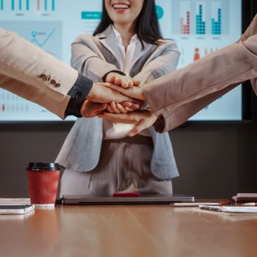 Business team stacking hands in unity during a meeting.