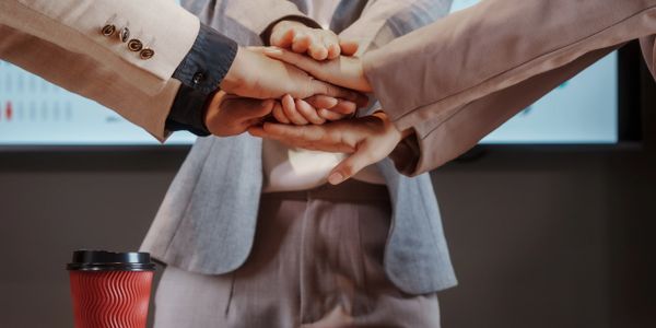 Business team stacking hands in unity during a meeting.