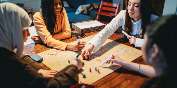 Group of friends playing a board game together, enjoying a fun evening.
