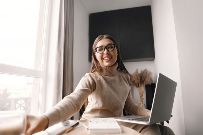 Beautiful happy woman working . Smiling business woman woman wearing eyeglasses in office,  using laptop computer.