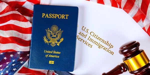 U.S. passport, immigration document, and judge's gavel on American flag.