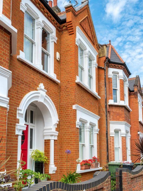 Row of traditional red brick houses with white accents.