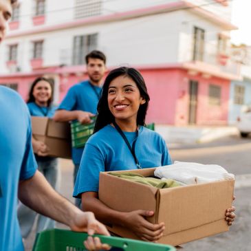 Volunteers carrying boxes during a community service event.