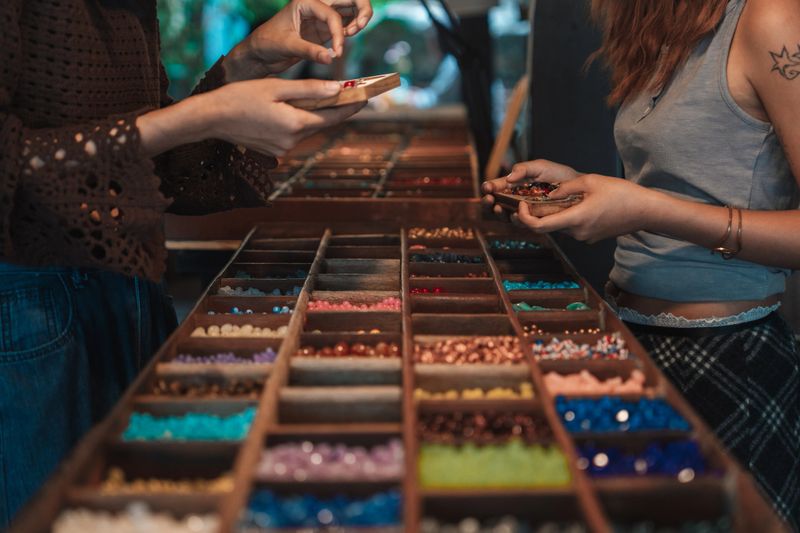 Two influencer friends filming each other in a handcrafted workshop, documenting their creative process and sharing the fun of making unique bracelets together