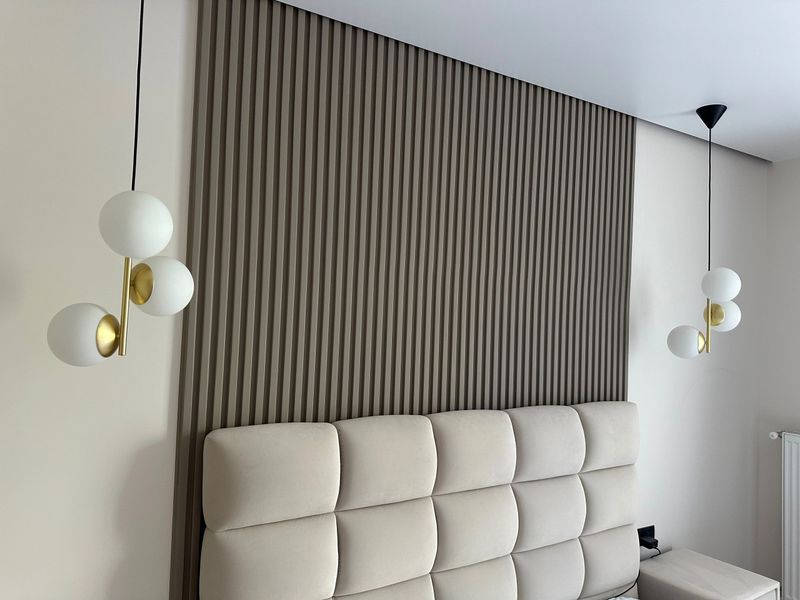 Stylish pendant lamps hanging on ceiling in bedroom