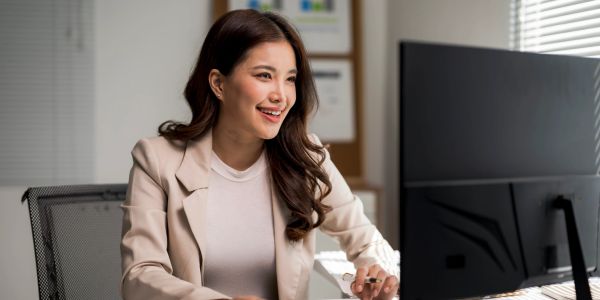 Woman smiling while working at a computer.
