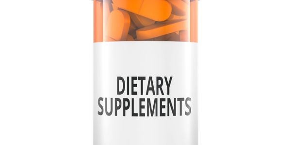 Bottle labeled 'Dietary Supplements' filled with orange capsules.