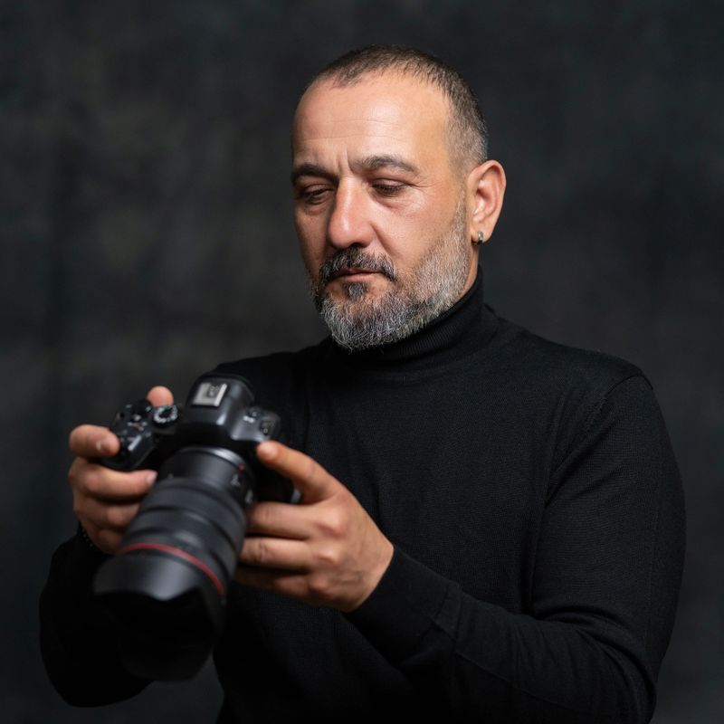 Portrait of Male Photographer Holding Camera in Studio